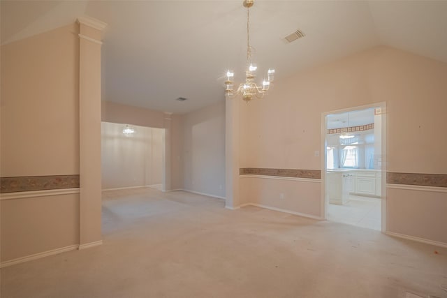 spare room featuring visible vents, light carpet, a notable chandelier, wainscoting, and vaulted ceiling