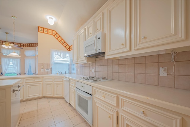 kitchen with white appliances, light tile patterned flooring, a sink, decorative backsplash, and decorative light fixtures