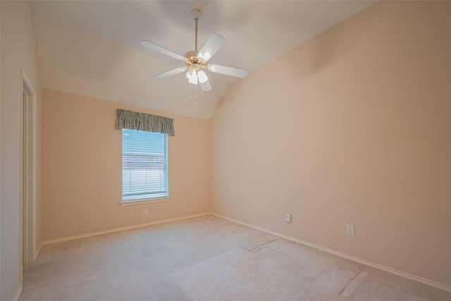 spare room with vaulted ceiling, light colored carpet, baseboards, and ceiling fan