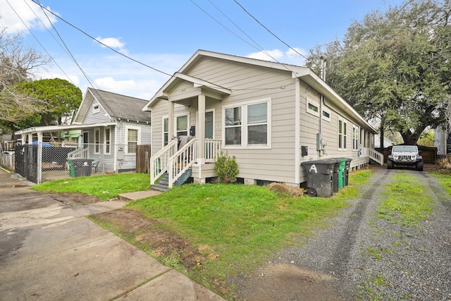 view of front of property with driveway, a front yard, and fence