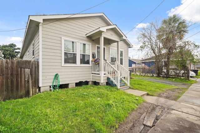 bungalow-style house featuring a front lawn and fence