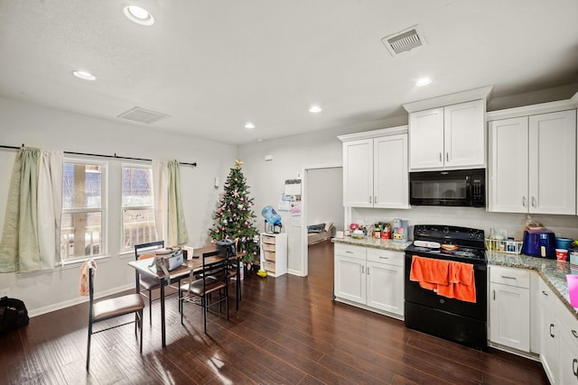 kitchen with visible vents, black appliances, white cabinets, and dark wood-style flooring