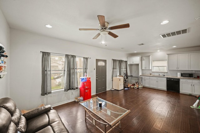 living room with recessed lighting, visible vents, plenty of natural light, and dark wood-type flooring