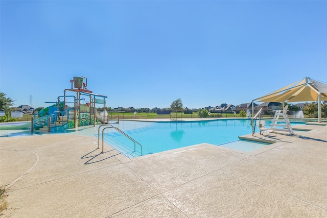 pool with a patio, playground community, and a water play area