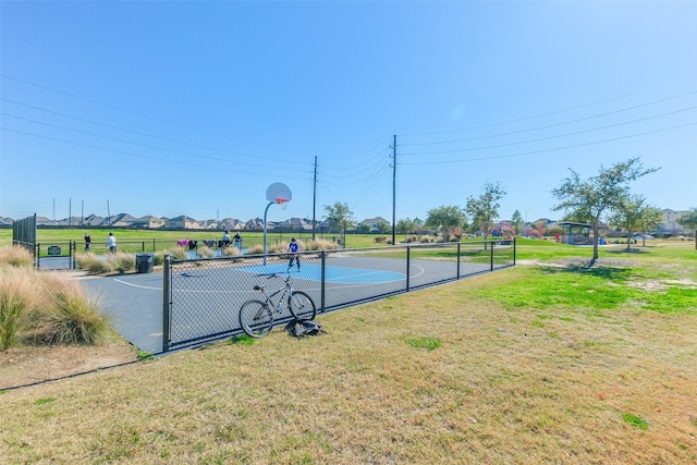 view of basketball court with a lawn, community basketball court, and fence