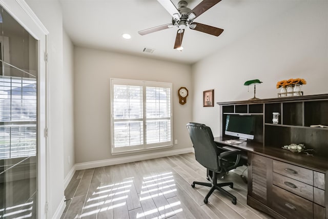 office space with a ceiling fan, baseboards, visible vents, and wood finish floors