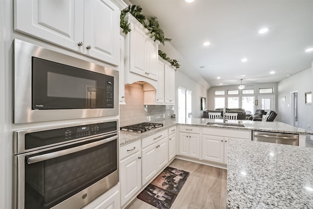 kitchen featuring a sink, stainless steel appliances, plenty of natural light, and backsplash