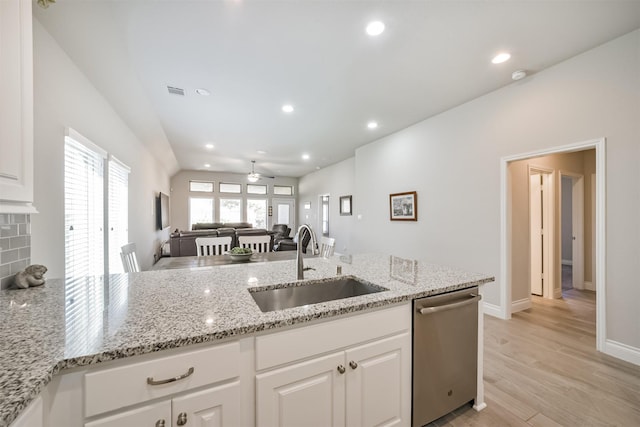 kitchen with stainless steel dishwasher, light wood finished floors, white cabinetry, and a sink