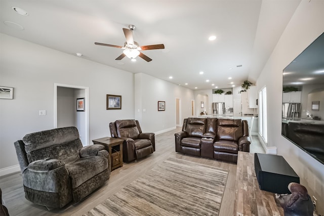 living room featuring recessed lighting, baseboards, light wood-style floors, and ceiling fan