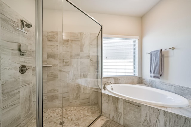 bathroom with a stall shower and a garden tub