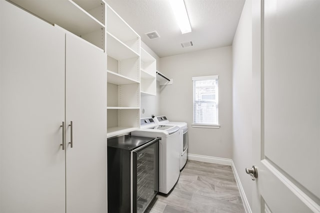 washroom featuring washing machine and clothes dryer, laundry area, baseboards, and visible vents