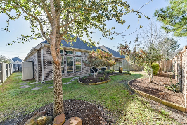 rear view of property with a yard, a fenced backyard, and brick siding