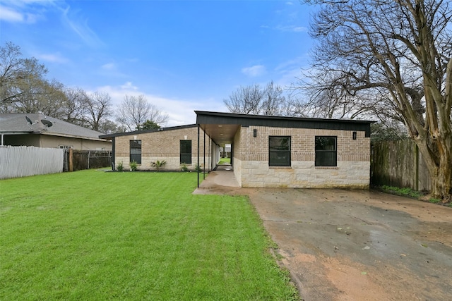 rear view of property featuring stone siding, a lawn, a fenced backyard, and a patio area