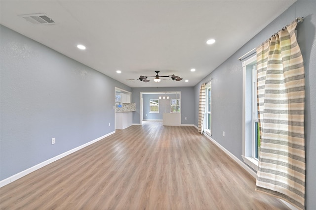 unfurnished living room featuring light wood finished floors, visible vents, recessed lighting, and baseboards