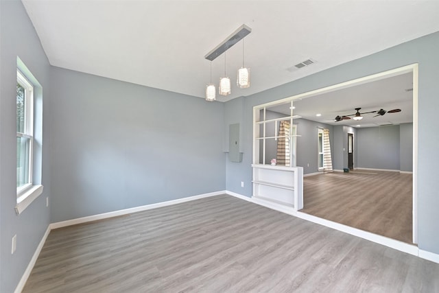 unfurnished room with ceiling fan, visible vents, baseboards, and wood finished floors