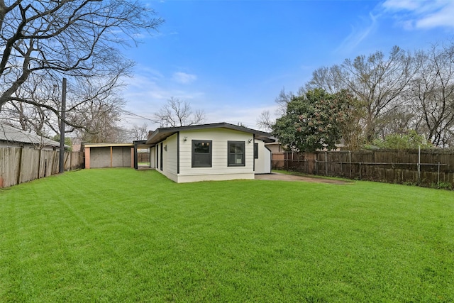 back of house with a yard and a fenced backyard