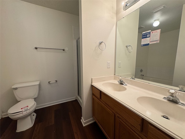 full bath featuring toilet, wood finished floors, baseboards, and a sink