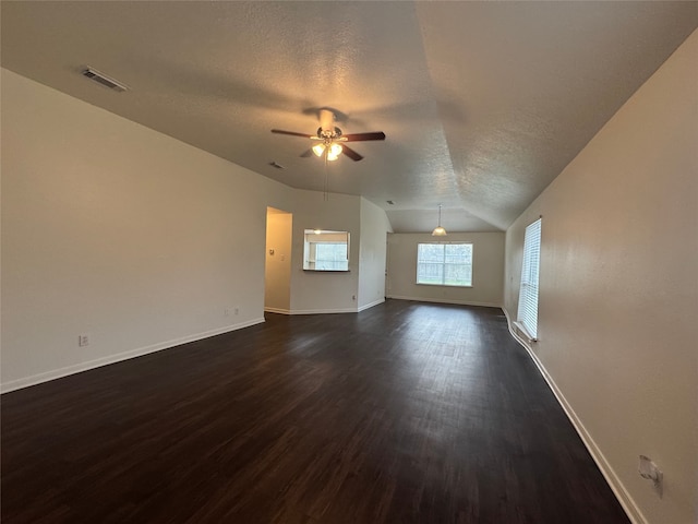 unfurnished living room featuring visible vents, ceiling fan, vaulted ceiling, a textured ceiling, and dark wood-style flooring