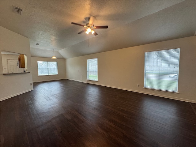 unfurnished living room featuring visible vents, baseboards, vaulted ceiling, dark wood-style floors, and a ceiling fan