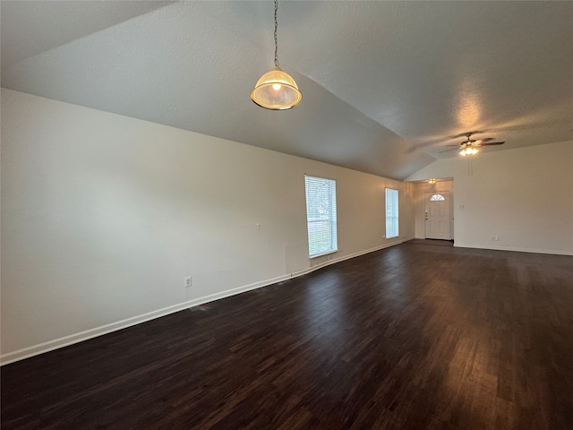 unfurnished living room featuring a ceiling fan, dark wood-style floors, baseboards, vaulted ceiling, and a textured ceiling