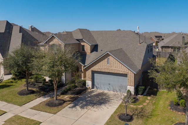 view of front of home with a front yard, concrete driveway, a garage, stone siding, and brick siding