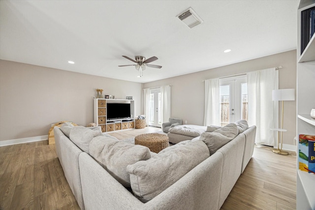 living room with wood finished floors, visible vents, baseboards, ceiling fan, and french doors