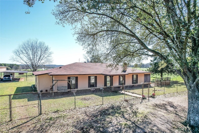 rear view of house featuring a fenced front yard, a lawn, and stucco siding