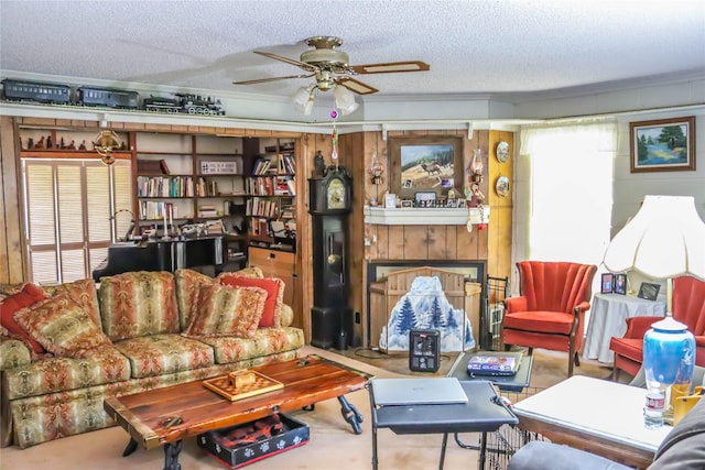 living area featuring a ceiling fan, crown molding, a fireplace, and a textured ceiling