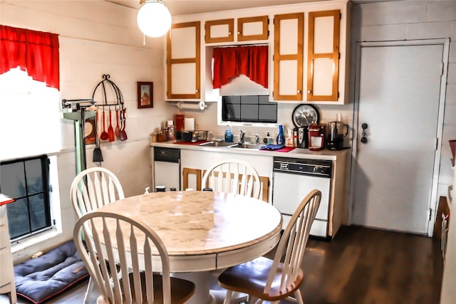 kitchen featuring a sink, dark wood-style flooring, light countertops, and white dishwasher