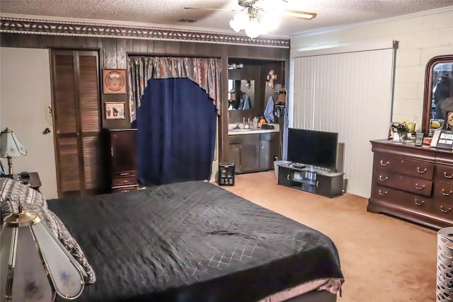 bedroom with concrete block wall, carpet flooring, a ceiling fan, and a textured ceiling