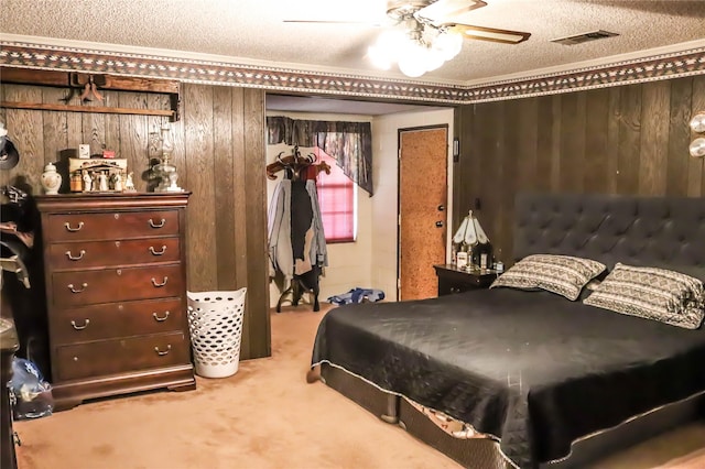bedroom with visible vents, wooden walls, a textured ceiling, and carpet flooring
