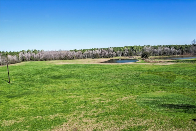 view of yard with a forest view and a water view
