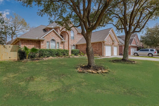 traditional home with a garage, brick siding, and a front yard