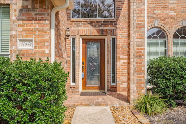 property entrance featuring brick siding