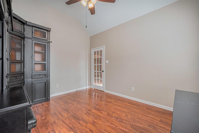 interior space featuring vaulted ceiling, wood finished floors, baseboards, and ceiling fan