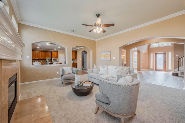 living room featuring visible vents, light colored carpet, ornamental molding, light tile patterned floors, and a fireplace