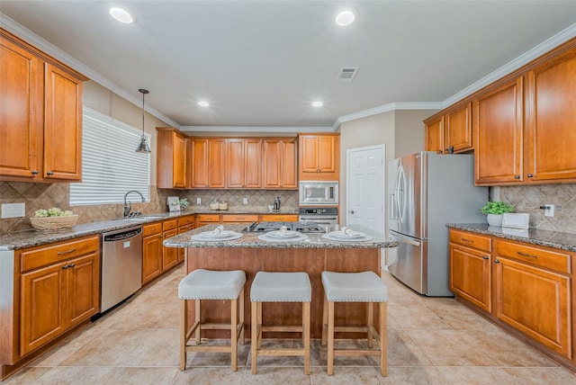 kitchen featuring a kitchen island, appliances with stainless steel finishes, a breakfast bar, and brown cabinetry