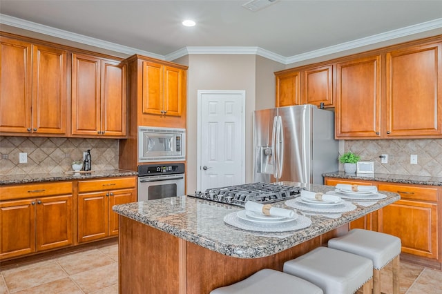 kitchen with stainless steel appliances, brown cabinets, and a breakfast bar