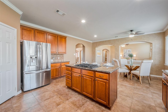 kitchen with stone countertops, brown cabinetry, visible vents, and stainless steel appliances