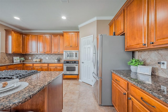 kitchen with dark stone countertops, brown cabinetry, and stainless steel appliances