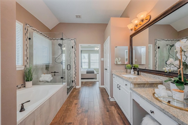 full bathroom featuring vanity, wood finished floors, vaulted ceiling, a shower stall, and a bath