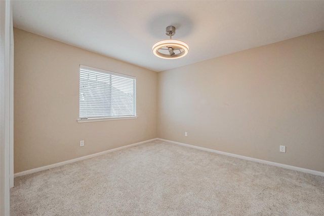 carpeted empty room featuring baseboards