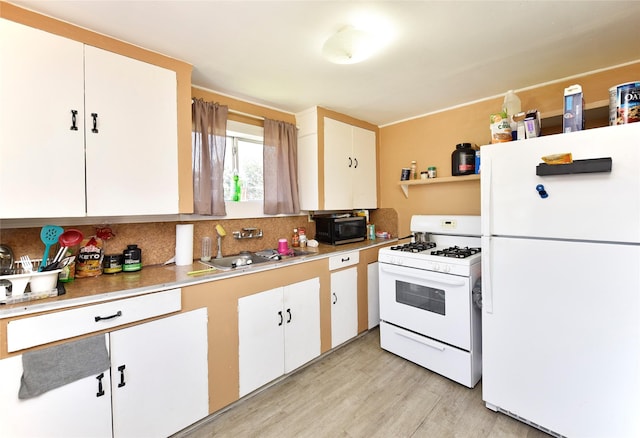 kitchen featuring backsplash, light countertops, white appliances, white cabinetry, and a sink