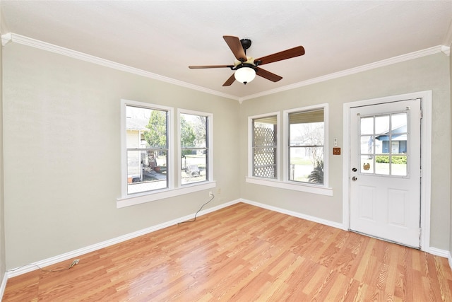 interior space featuring a wealth of natural light, light wood-style flooring, crown molding, and baseboards