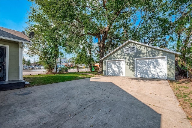 detached garage featuring fence