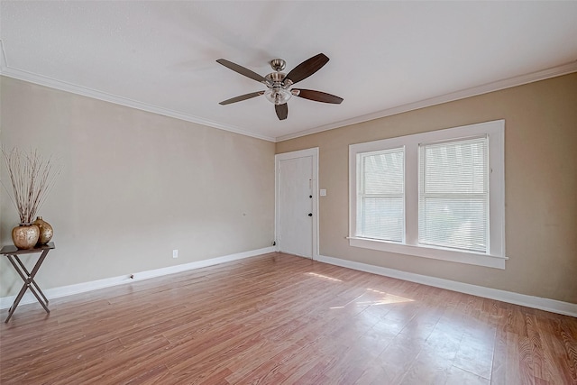 empty room with a ceiling fan, crown molding, baseboards, and light wood-type flooring