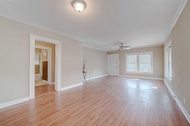 spare room with baseboards, light wood-style flooring, and ornamental molding