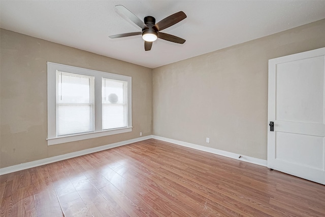 unfurnished room featuring light wood finished floors, a ceiling fan, and baseboards