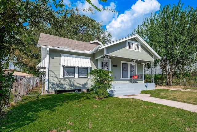 bungalow-style house with covered porch, a front yard, and fence