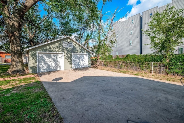 detached garage featuring fence